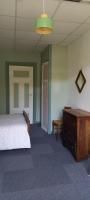 a bedroom with a bed and a dresser and a table at Le green in Lamastre