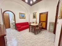 Una sala de estar con un sofá rojo y una mesa. en Casa Leandra, en Civitavecchia
