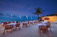 a group of tables and chairs on the beach at night at Lembongan Beach Club & Resort in Nusa Lembongan