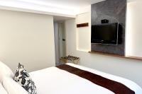 a bedroom with a bed and a flat screen tv on the wall at Dafong Hotel in Zhongzheng