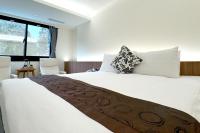 a bedroom with a large white bed with two pillows at Dafong Hotel in Zhongzheng