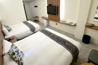 a hotel room with two beds and a flat screen tv at Dafong Hotel in Zhongzheng