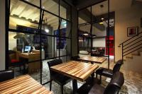 a restaurant with wooden tables and chairs and glass walls at 1999 B&amp;B in Hualien City