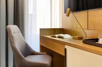 uma cadeira ao lado de uma secretária com um candeeiro em Mercure Tirana em Tirana