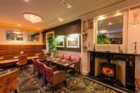 ニューリーにあるFlagstaff Lodgeの暖炉、テーブル、椅子が備わるレストラン