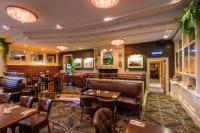 ニューリーにあるFlagstaff Lodgeのテーブルと椅子とバーのあるレストラン