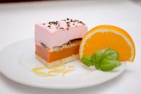 a piece of cake and an orange slice on a plate at Jaśminowy Dwór in Rokietnica