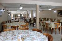 een eetkamer met tafels en stoelen en een cafetaria bij HOTEL FAZENDA ROCHEDO in Conservatória