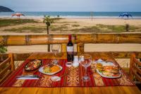 a table with food and a bottle of wine on a beach at Victor Hugo Hotel in Puerto López