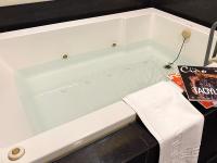 a bath tub filled with water sitting next to a table at Spa Spring Resort in Taipei