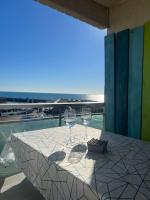 a table with two wine glasses sitting on a balcony at Superbe Appartement Vue Mer T3 70m2 in Mauguio