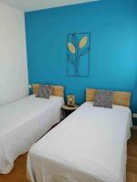 two beds in a room with a blue wall at Superbe Appartement Vue Mer T3 70m2 in Mauguio