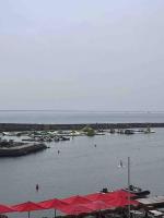 a harbor with boats in the water with red umbrellas at Superbe Appartement Vue Mer T3 70m2 in Mauguio