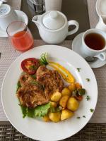 KasenyiにあるElephant View Lodgeのテーブルの上に置かれた肉と野菜の料理の皿