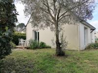a small white house with a tree in the yard at Aux Caboteurs in Arzal