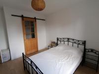 a bedroom with a bed with white sheets and a wooden door at Aux Caboteurs in Arzal