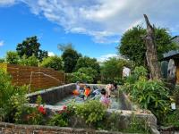 a group of children playing in a garden fountain at 寧靜的家14人Villa獨立設施包棟戲水池烤肉區麻將廚房私人停車場 in Hengchun South Gate