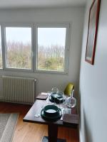 a table with dishes on it in a room with two windows at Sangatte Guest Room - Le Sunset - in Sangatte