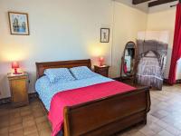 a bedroom with a bed with a red blanket and a mirror at Gîte Cherves-Richemont, 3 pièces, 5 personnes - FR-1-653-205 in Cherves-de-Cognac