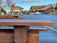 una mesa de picnic de madera frente a un aparcamiento en Oppdalsporten Motell, en Oppdal