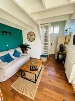 ein Wohnzimmer mit einem Sofa und einem Tisch in der Unterkunft Au chant des mouettes in Cabourg