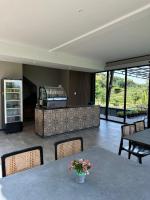 Una sala de estar con mesas y sillas y una cocina. en Svarna Padi, en Grigak