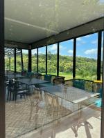 Una gran sala con mesas, sillas y ventanas. en Svarna Padi, en Grigak