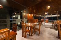 jadalnia z drewnianymi stołami i krzesłami w obiekcie Tara Waterfall w mieście Rakwana