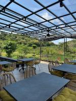 un patio con mesas y sillas bajo una pérgola en Svarna Padi, en Grigak