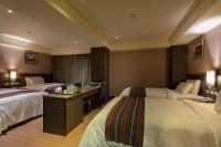 a hotel room with two beds and a desk at Royal Guest Hotel in Tainan