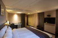 a hotel room with a bed and a flat screen tv at Royal Guest Hotel in Tainan