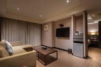 a living room with a couch and a tv at Royal Guest Hotel in Tainan