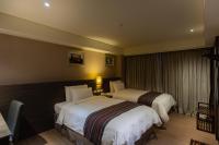 a hotel room with two beds and a table at Royal Guest Hotel in Tainan