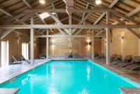 - une piscine dans un bâtiment doté d&#39;un plafond en bois dans l&#39;établissement Hôtel Restaurant Spa Les Jardins De Sophie, à Xonrupt-Longemer