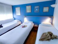 two beds in a room with a blue wall at greet Hotel Belleville en Beaujolais A6 in Belleville-sur-Saône