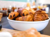 a bowl of croissants and other pastries on a table at greet Hotel Belleville en Beaujolais A6 in Belleville-sur-Saône