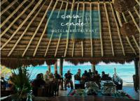 un gruppo di persone sedute in un ristorante sulla spiaggia di Casa Cenote Hotel a Tancah