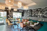 een restaurant met tafels en stoelen en een muur met graffiti bij The Rockley by Ocean Hotels - Breakfast Included in Bridgetown