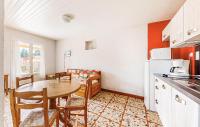 a kitchen and dining room with a table and a refrigerator at Lovely Home In Saint-savinien With Outdoor Swimming Pool in Saint-Savinien
