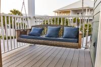 eine Korbschaukel auf einer Veranda mit blauen Kissen in der Unterkunft Summer Breeze D212 - Bungalow 6 in Destin