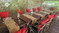 Una larga mesa de madera con sillas rojas y copas de vino. en Masai Mara Zanzibar - Boutique Hotel, en Jambiani