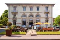 a building with tables and umbrellas in front of it at Hotels &amp; Résidences - Les Thermes in Luxeuil-les-Bains