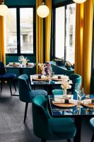 Un comedor con mesas y sillas y ventanas. en Hôtel-Restaurant Bel Ami, en Pacy-sur-Eure