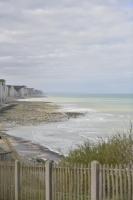 a view of a beach with a fence and the ocean at Le Cottage de la Baie - vue mer en Baie de Somme in Woignarue