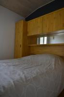 a bedroom with a bed and wooden cabinets at Le Cottage de la Baie - vue mer en Baie de Somme in Woignarue
