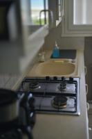 a stove top oven with a sink in a kitchen at Le Cottage de la Baie - vue mer en Baie de Somme in Woignarue