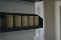 a shelf with six brown canning jars on it at Le Cottage de la Baie - vue mer en Baie de Somme in Woignarue