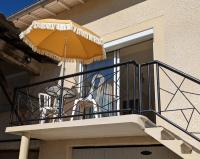a balcony with an umbrella on a house at comme à la maison in Clonas-sur-Varèze
