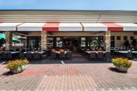 un ristorante all'aperto con tavoli, sedie e fiori di Villa Gasparina a Ronchi