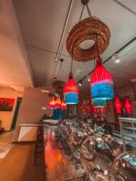 Un bar con candelabros rojos y azules en un restaurante. en Grey Escape Apartments, en Qalḩāt